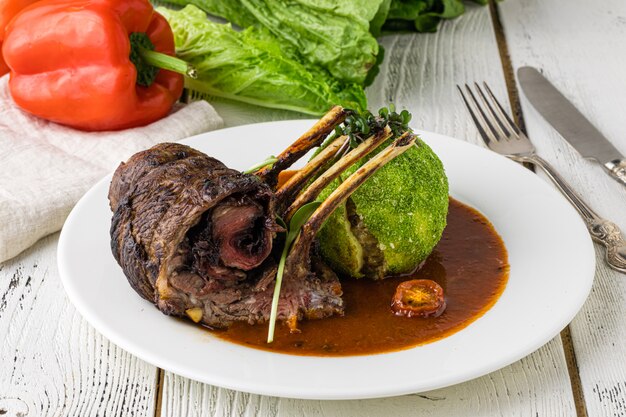 Bife com legumes grelhados em uma frigideira, foco seletivo