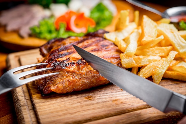 Bife com molho de pimenta e legumes grelhados na tábua