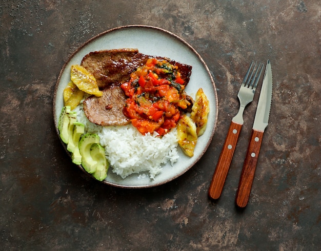 bife com molho de tomate, arroz, batata frita com abacate e banana