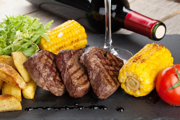 Bife com salada de milho de batata grelhada e vinho tinto