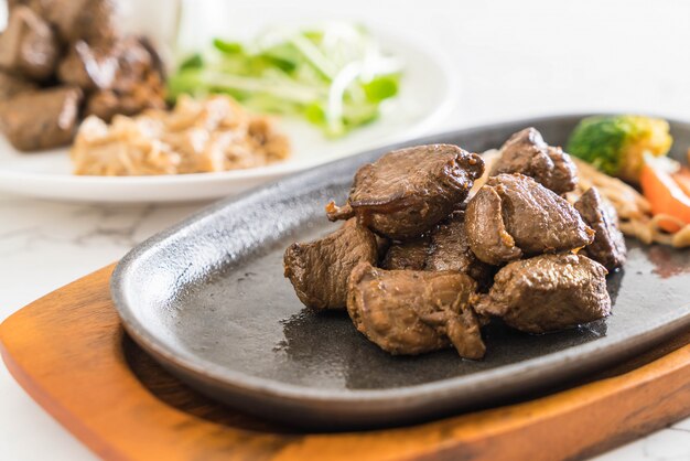 Fígado de frango frito ou assado com cebola e molho folhas de salsa verde  num prato prato de carne enriquecido com ferro