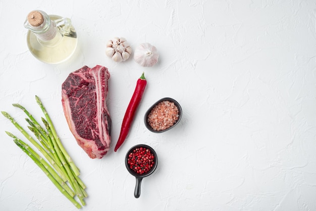 Bife cru com conjunto de ingredientes, na pedra branca