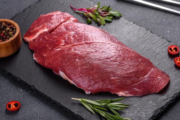 Bife cru de Chuck roll com ervas e sal em uma tábua de cortar