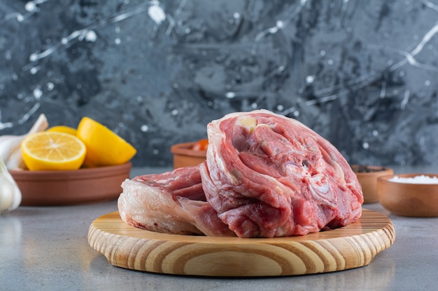 Bife cru na tábua de madeira com legumes frescos.