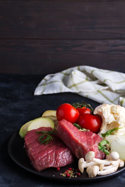 Bife cru no osso com legumes frescos em uma panela de grelhar