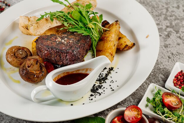 Bife de carne assada com batatas fritas cogumelos molho de tomate e ervas