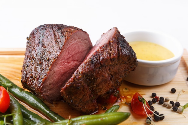 Bife de carne com molho em uma tábua de madeira