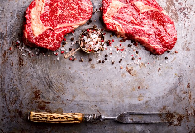 Bife de carne crua marmorizada fresca e garfo de carne