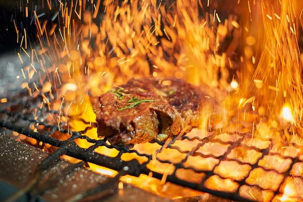 Bife de carne crua na grelha com fogo