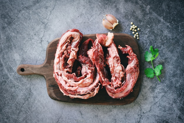 Bife de carne crua para churrasco com alho especiarias na tábua de madeira, vista superior - churrasco grelhado de açougueiro fresco de carne magra