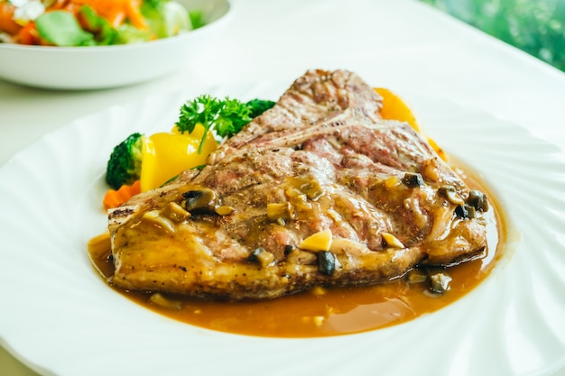 Bife de carne de bovino grelhado em t-bone com vegetais