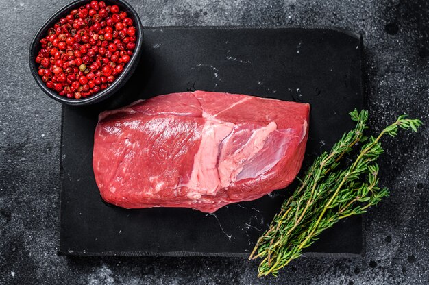 Bife de carne de cordeiro crua em uma tábua de pedra