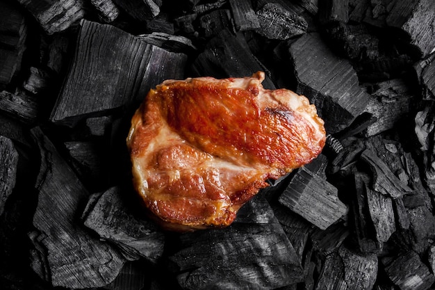 Bife de carne frita em um fundo preto de carvão Bife suculento cozido nas brasas