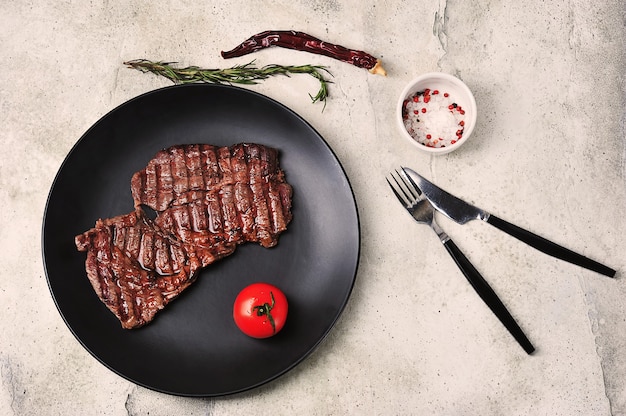 Bife de churrasco cozido em uma vista de placa preta