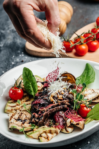 Bife de churrasco fatiado com salada de legumes grelhados, nozes, molho e parmesão. conceito de cozinha italiana.