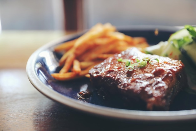 Bife de costela de porco assada com legumes frescos em uma velha rústica de madeira no restaurante