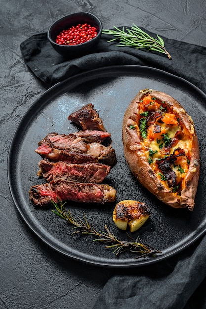 Bife de costela decorado com batata doce assada. Bife grelhado.