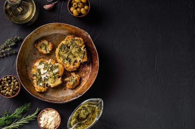 Bife de couve-flor com especiarias molho chimichurri flocos de amêndoa Alcaparras azeitonas ervas lado a lado Fundo escuro Comida vegetariana Copyspace