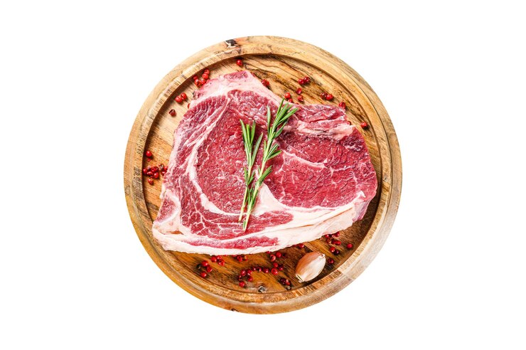 Foto bife de cowboy cru ou ribeye no osso em uma tábua de corte carne de vaca de mármore fundo branco isolado