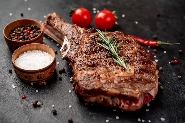 bife de cowboy grelhado com temperos em uma faca em uma mesa de pedra