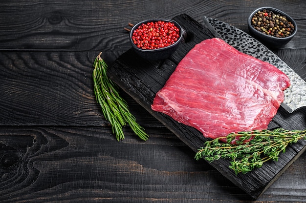 Bife de flanco cru ou bavette em uma tábua de madeira