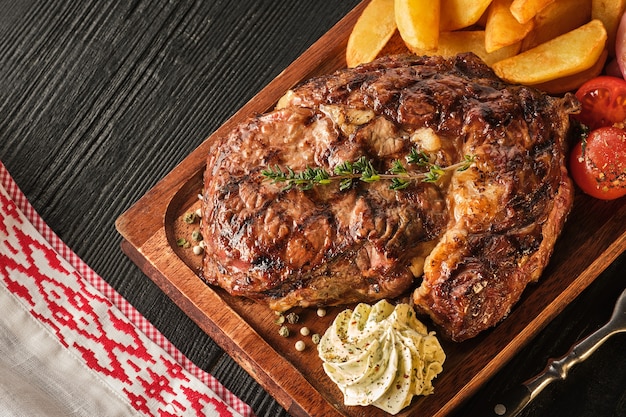 Bife de lombo com batata, cebola e tomate cereja assado. bife suculento com manteiga aromatizada.