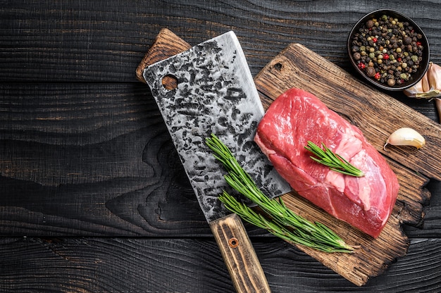 Bife de lombo de cordeiro cru em uma tábua de madeira