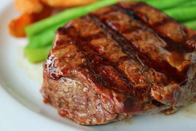 Bife de lombo grelhado fechado com turva vegetal no fundo