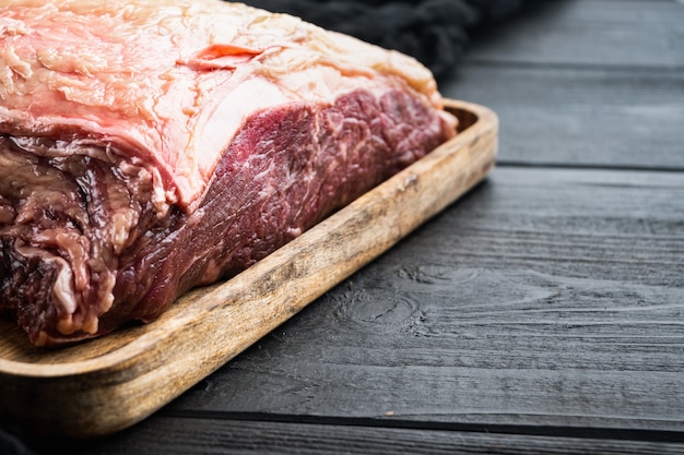 Bife de Nova York, carne bovina crua, na mesa de madeira preta,