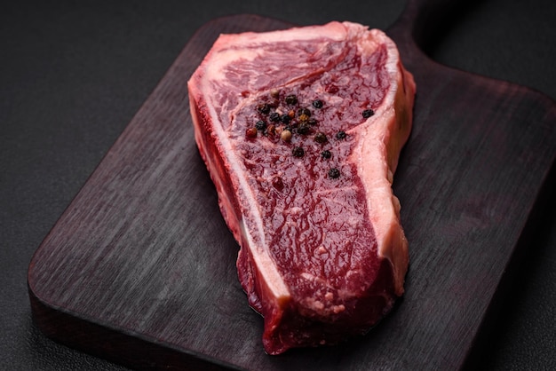 Bife de Nova York cru suculento fresco com ervas e especiarias de sal