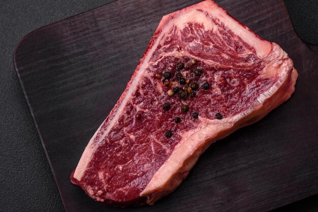 Bife de Nova York cru suculento fresco com ervas e especiarias de sal