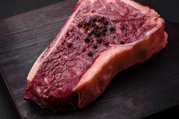 Bife de Nova York cru suculento fresco com ervas e especiarias de sal