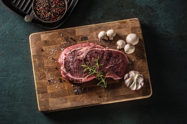 Bife de olho de costela sal pimenta especiarias alho e cogumelo. carne bovina crua no açougue - topo da vista.