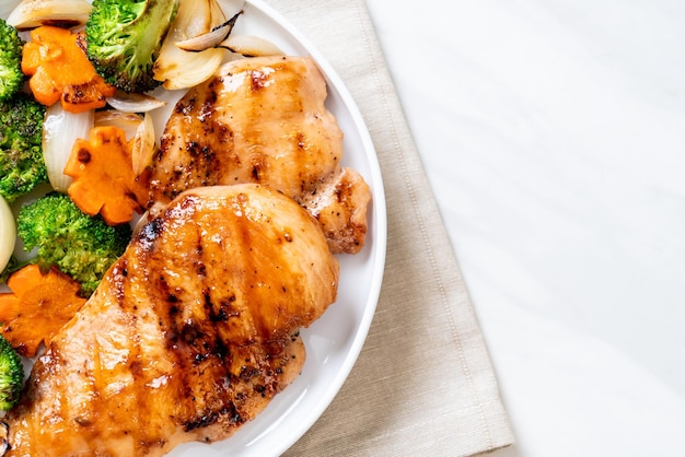 Foto bife de peito de frango grelhado com vegetais (brócolis, cenoura, cebola)