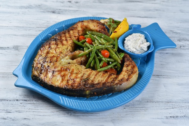 Bife de peixe com aspargos e molho, bife de salmão com legumes, prato de frutos do mar, vista superior