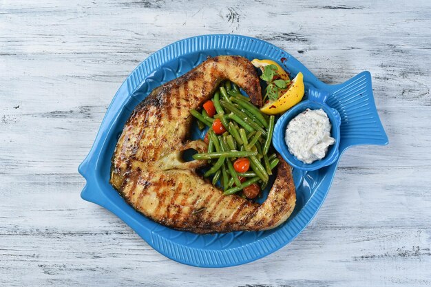 Bife de peixe com aspargos e molho, bife de salmão com legumes, prato de frutos do mar, vista superior