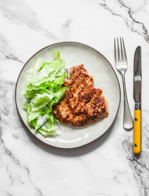 Bife de peru grelhado e molho de salada de iogurte grego iceberg em uma vista superior de fundo leve Delicioso almoço saudável