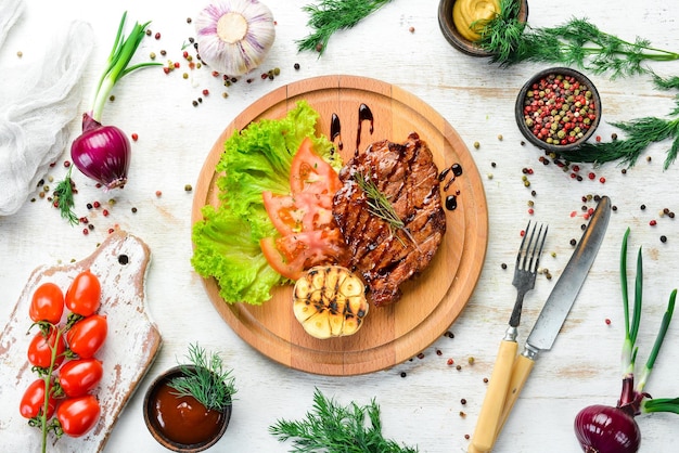 Bife de porco assado suculento com legumes na placa Vista superior