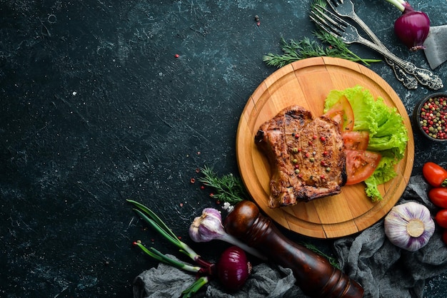 Bife de porco com osso com legumes no tabuleiro Menu de churrasco Vista superior