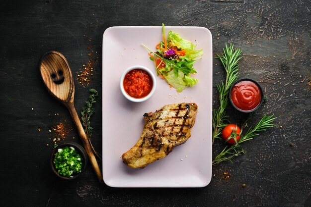 Bife de porco com osso com salada e molho Vista superior Espaço livre para o seu texto