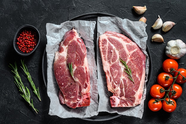 Bife de porco cru. Carne de mármore em papel vegetal. Vista do topo.