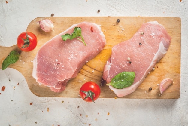 Bife de porco cru na mesa de madeira