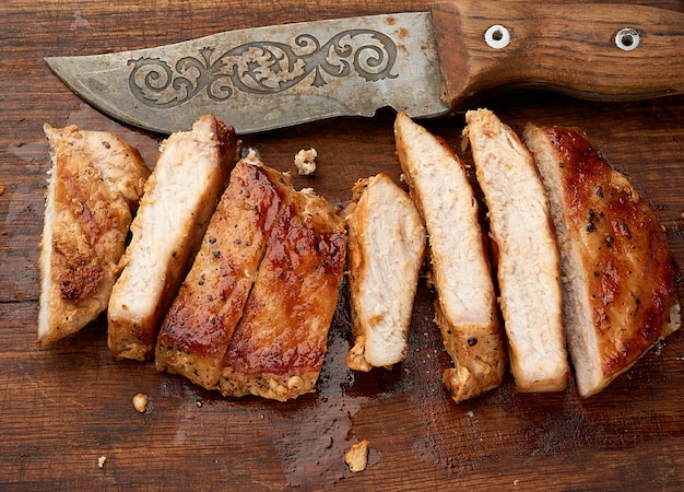 Foto bife de porco frito fatiado em listras em uma tábua de cozinha