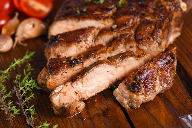 Bife de porco frito fatiado em uma placa de madeira