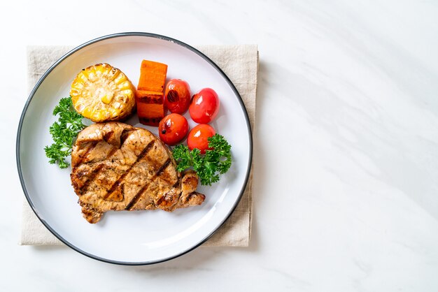 Bife de porco grelhado e churrasco com milho, cenoura e tomate