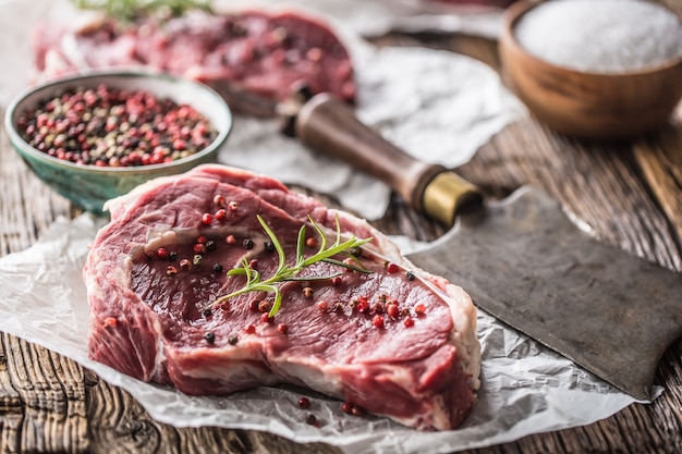 Bife de Rib Eye com sal pimenta e alecrim na mesa de madeira.