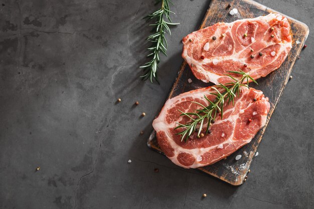 Bife de Ribeye Cru. Em uma mesa de pedra preta. Vista do topo. Espaço livre para seu texto.