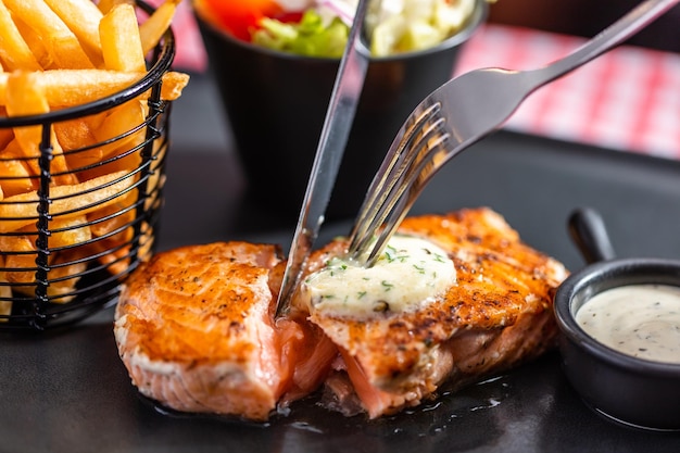 Bife de salmão com salada e batatas fritas em restaurante americano