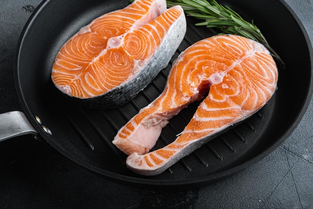 Bife de salmão cru na frigideira grelha sobre fundo cinza