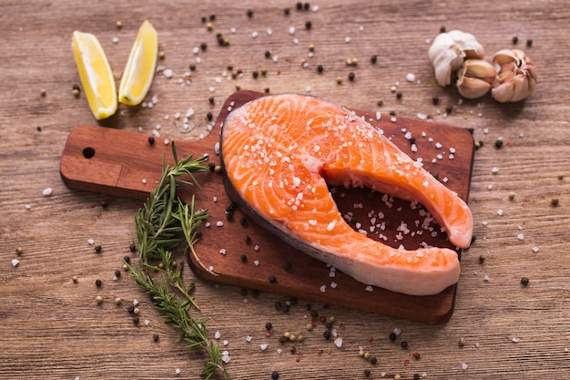 Bife de salmão cru na tábua de madeira